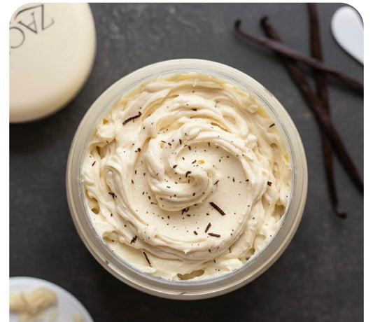 Container of whipped cream with vanilla beans on a dark surface